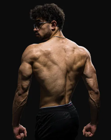 Austin from behind, flexing his back under hard light.